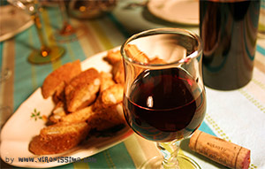 A glass of Recioto wine on a table with almond cookies