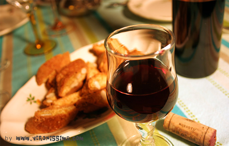 a glass or Recioto wine on a table with almond cookies