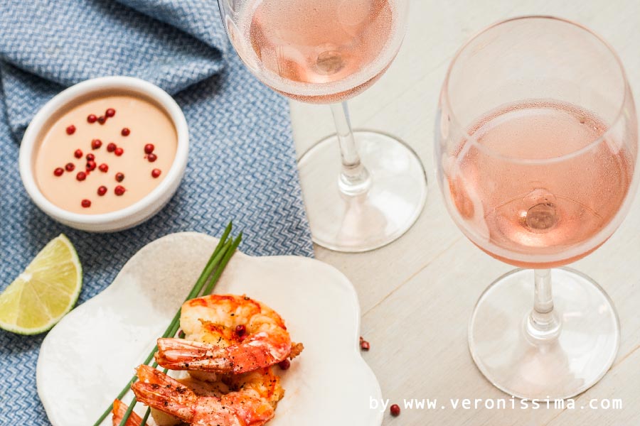 two glasses of Bardolino sparkling rose and a small dish of shrimps