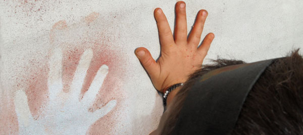 un bambino lascia l'impronta della mano su una parete rocciosa