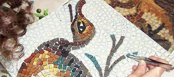 Una ragazza realizza un mosaico raffigurante un'anatra