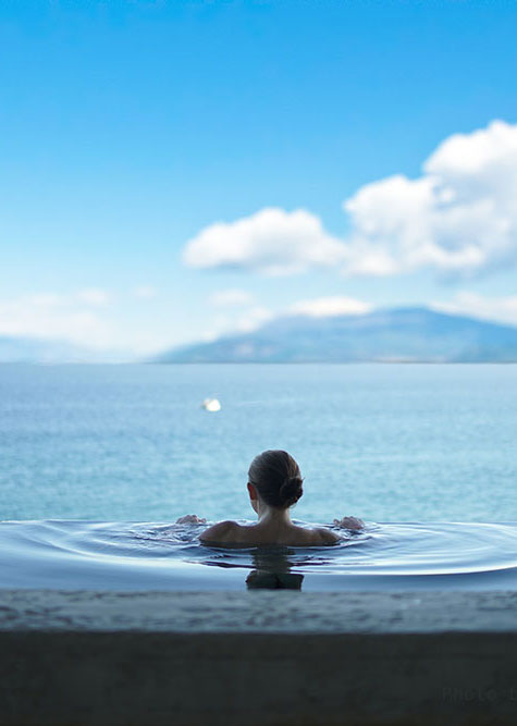 donna immersa in una vasca termale di fronte al lago
