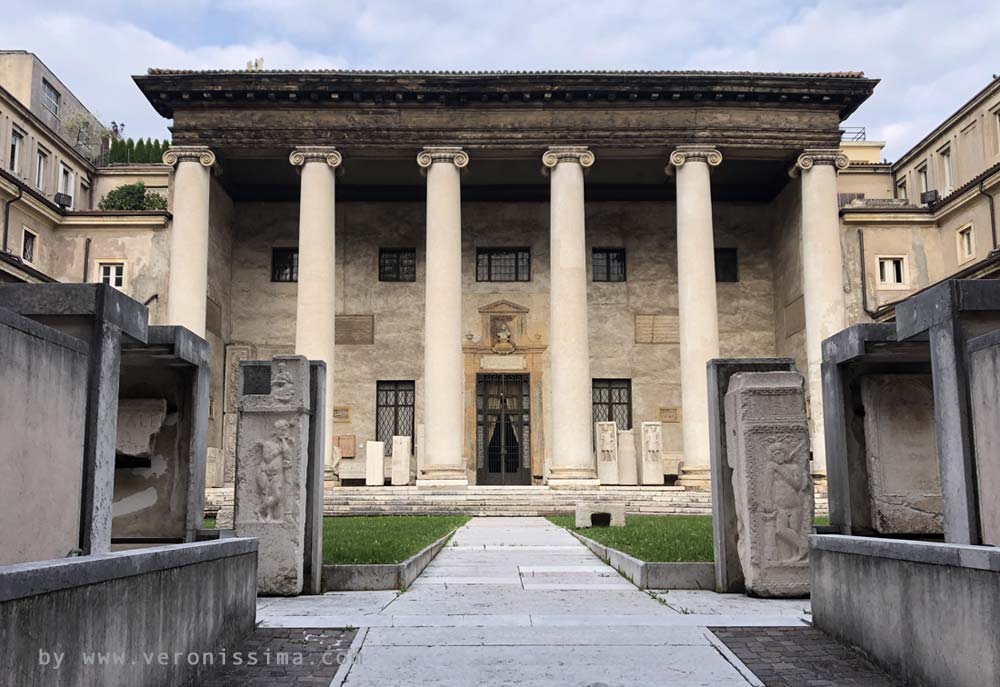 The pronao with gigantic colums of the Philarmonic Theater of Verona and the couryard with the Lapidario Maffeiano museum exhibits