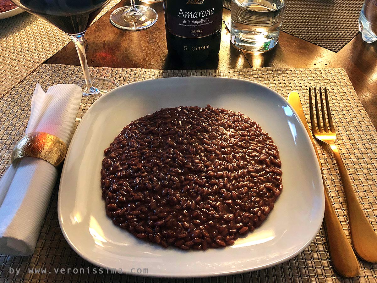risotto on a dish and a bottle of Amarone wine on the background