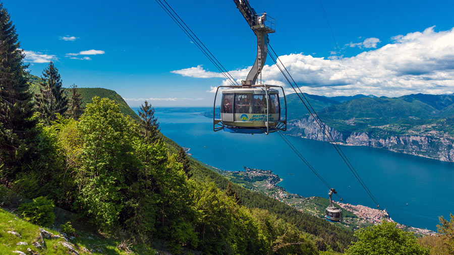 Le cabine della funivia Malcesine Monte Baldo e in lontananza sfondo in basso il lago di Garda