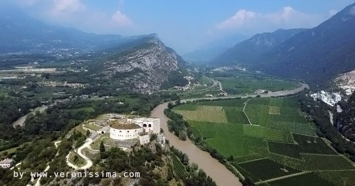 The narrow sides of river Adige valley flanked by mountains and Rivoli fortress on the foreground