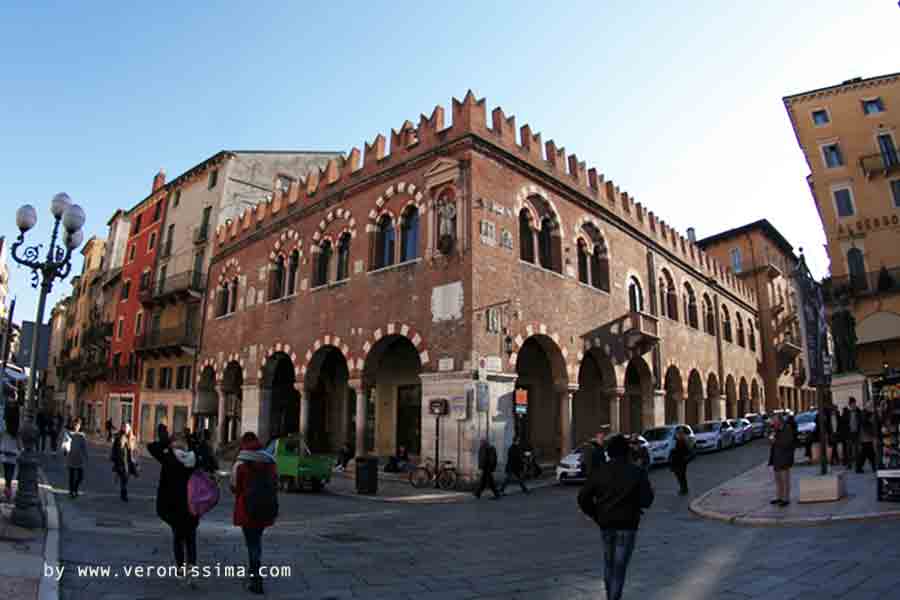 La domus mercatorum in mattoni e con la merlatura ghibellina in piazza Erbe