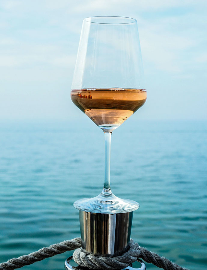 un calice di Bardolino Chiaretto rosé e il lago sullo sfondo