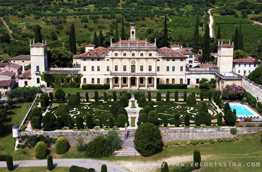 Villa Arvedi con il davanti il giardino all'italiana e le colline ricoperte di vigneti alle spalle