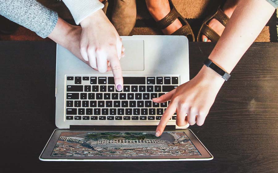 Three girls follow a distance tour through a computer